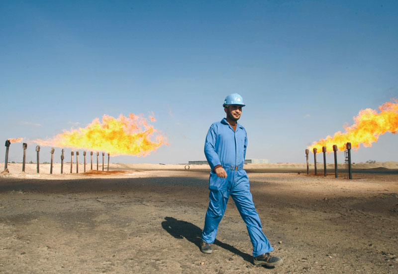 An engineer walks past the chimneys at the Barjisiya oil fields in Zubair One An engineer walks past the chimneys at the Barjisiya oil fields in Zubair One